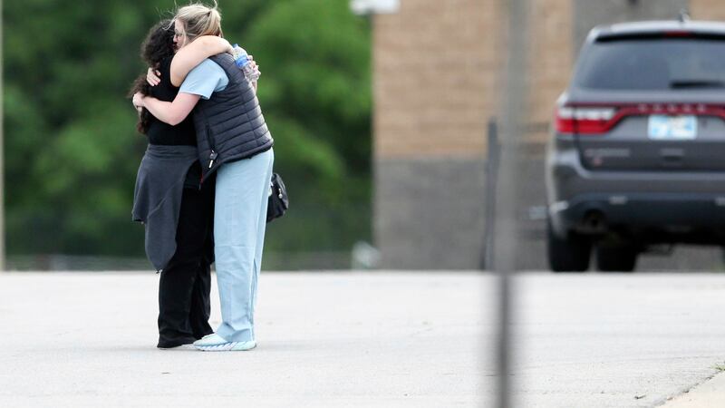 Two people hug as they are reunited at Memorial High School after being evacuated from the...